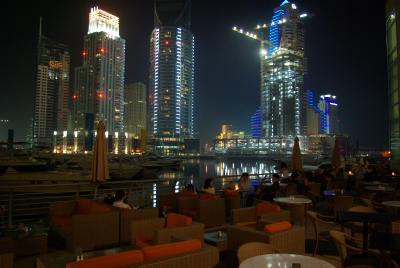 Nachts ist die Stadt hell beleuchtet, ueberall stehen Kraene und gleissenden Licht macht die Baustellen zu einer Showbuehne